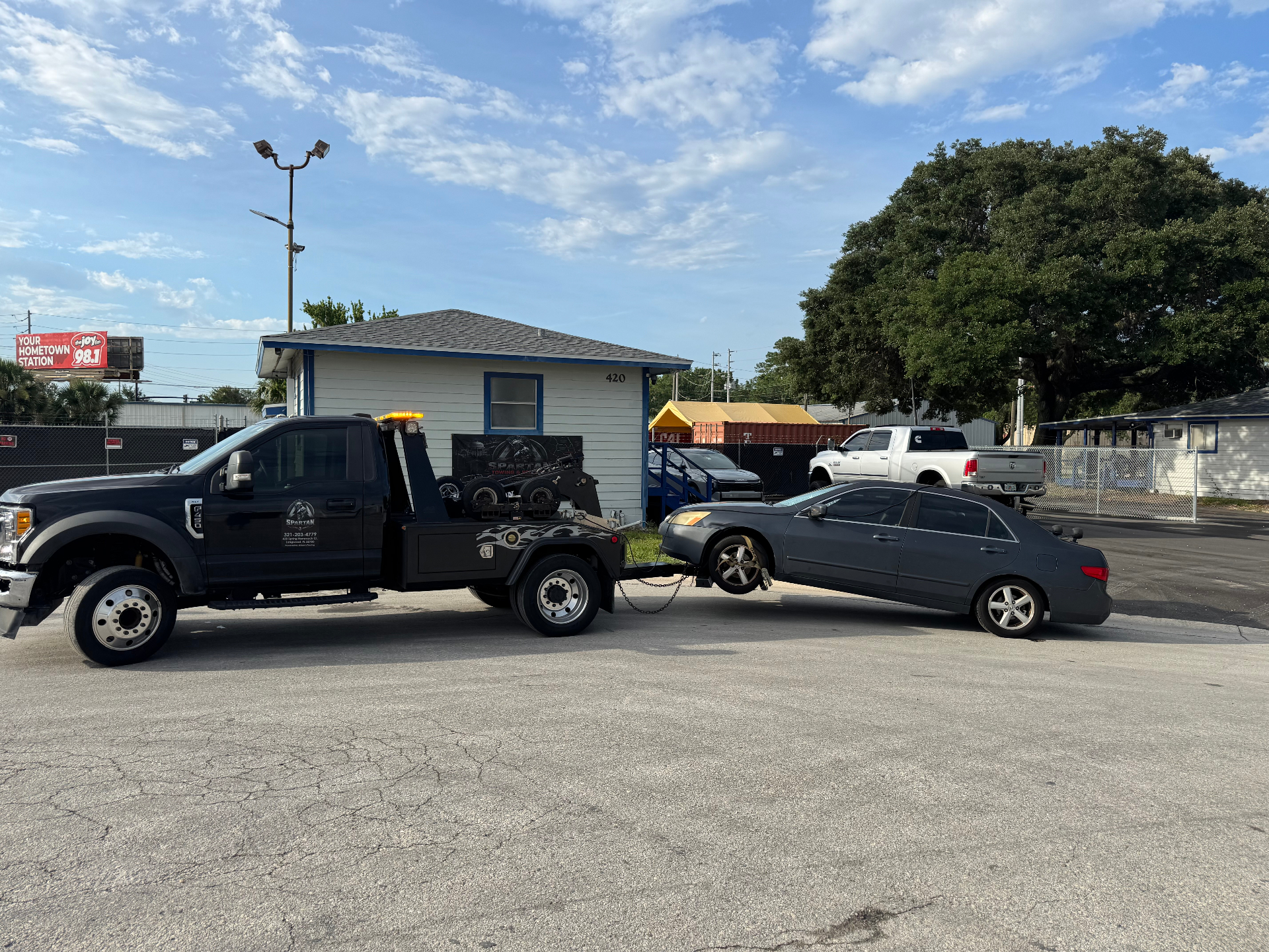 Spartan Towing flatbed truck towing a sedan in Longwood, FL